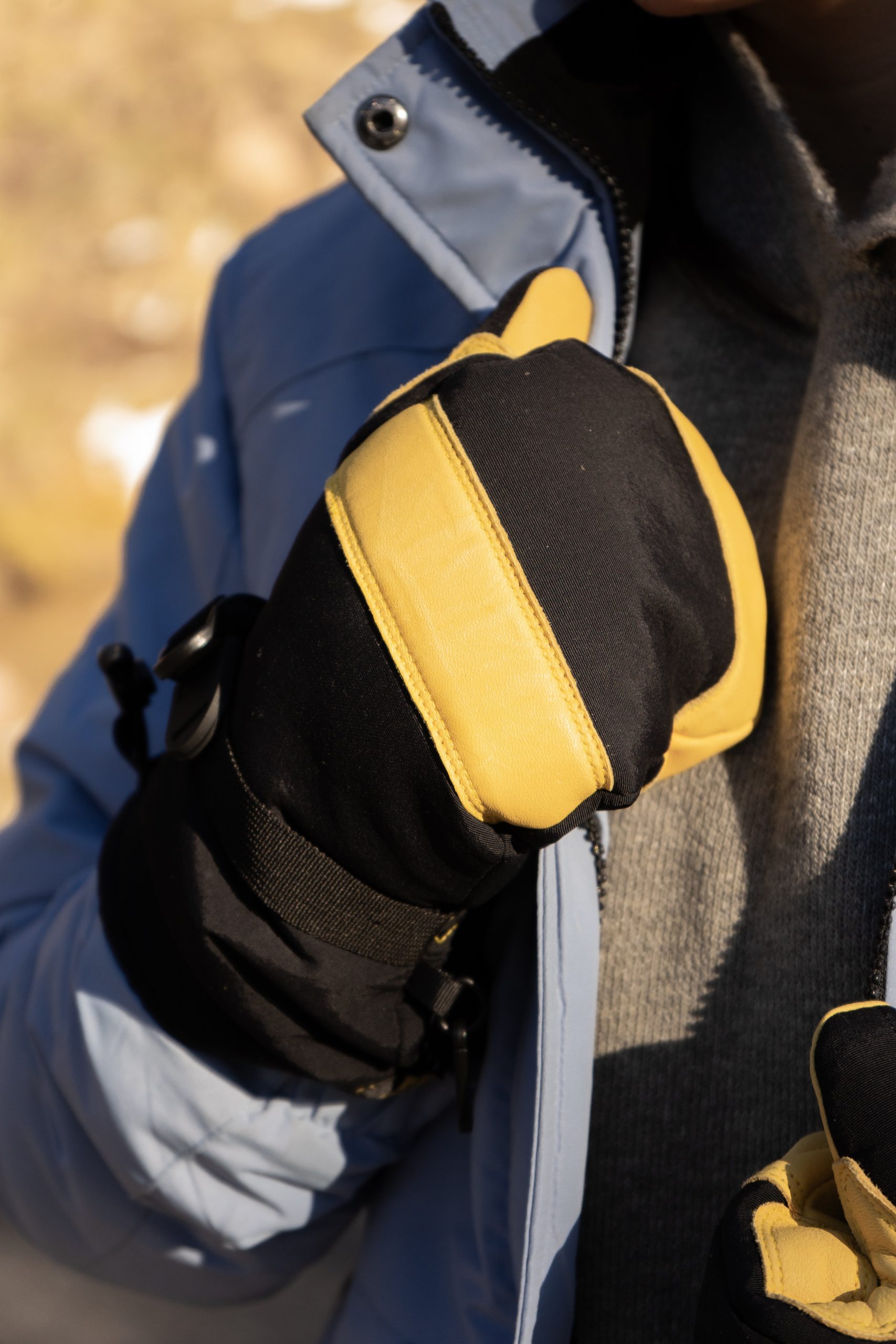 Deerskin leather ski mitt holding a jacket