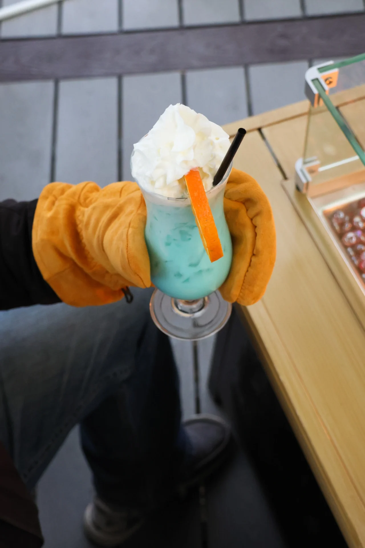 Orange Saranac Cedar Frost Glove Holding a Smoothie