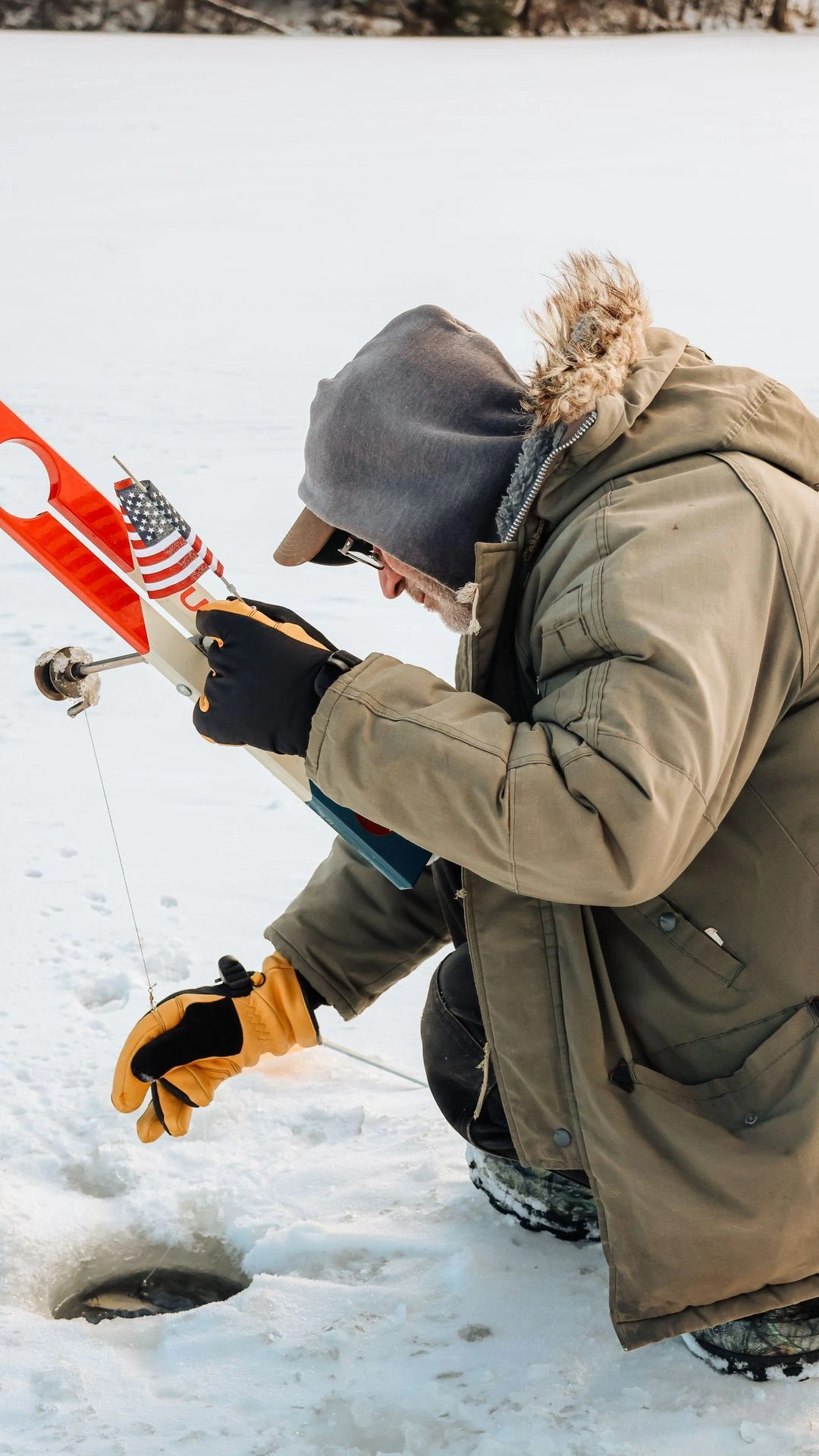 Person wearing saranac gloves reaching down ice